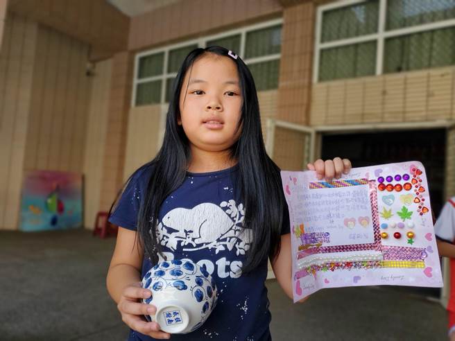 一个小朋友在写给妈妈的信上贴满闪亮的珠子。（周丽兰摄）