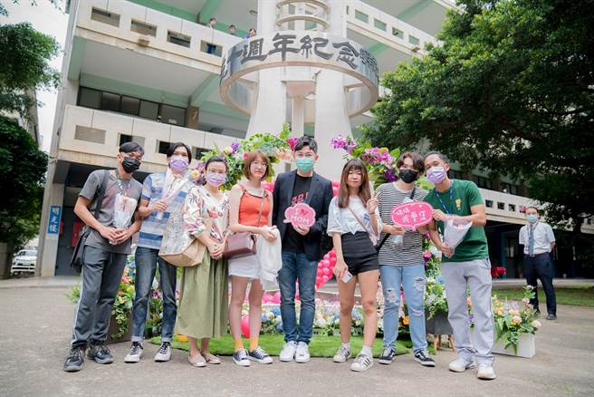 明新科大时尚造型与设计系李明川(右4)、郑媛伊老师(左3)带领同学「Flower Flash」花艺创作快闪，将校内地标用日本人造拟真花的康乃馨、桔梗等花材布置出「妈·妈咪啊的花园」，成为期间限定的打卡拍照热点。（图/明新科大提供）