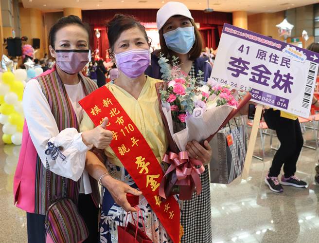 羅美菁局長(左一)贈花祝賀阿美族李金妹女士(中)獲模範母親。（原民局提供）
