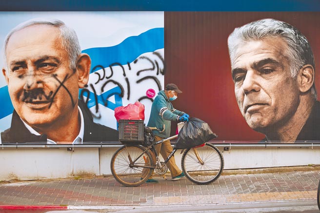 今年3月以色列国会选举期间，特拉维夫东边的拉马特甘市街头，以国总理纳坦雅胡（左）的竞选看板遭人涂鸦，右边则是在野「未来党」党魁拉皮德（右）的看板。（美联社）