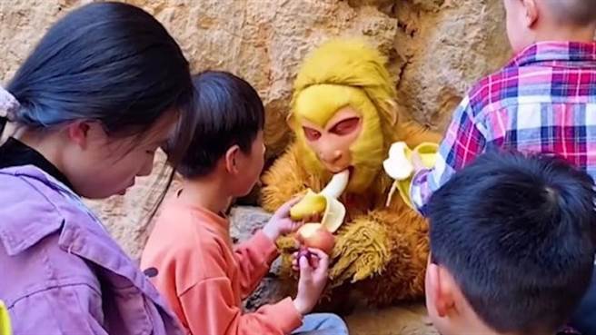 扮孙悟空压五指山被「喂食」，本尊求饶：「不要再喂了」网笑翻。（图／翻摄自「点时新闻」）。