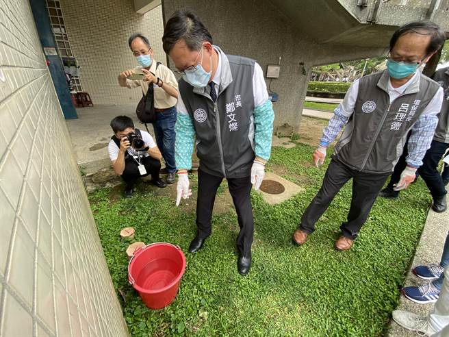桃园市长郑文灿8日宣布提早启动登革热防治工作，除在350里设置3500个诱卵桶，他也亲示范「巡、倒、清、刷」，果真发现路边废轮胎、庙宇盆栽盘都积满水，呼吁全市动起来。(蔡依珍摄)
