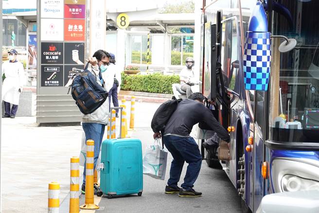 搭乘日航专机自印度返台的旅客，8日中午抵达台北松山机场，经防疫消毒后，乘坐游览车前往集中检疫所。（姚志平摄）