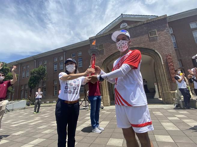 成功大學睽違40年再度主辦全國大專院校運動會，首度以跑步完成19天1168公里環台聖火傳遞，8日聖火隊跑抵成大，由成大造船系73級校友陳財富（右）將聖火交給校長蘇慧貞。（曹婷婷攝）