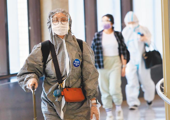 國內今新增4例境外移入確定病例，自菲律賓(案1212至案1214)及印度(案1215)入境。圖為身穿防護衣的旅客準備通關入境。（范揚光攝）