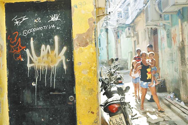 巴西警方6日大舉突襲里約以北的貧民窟，掃蕩涉嫌走私毒品的黑幫，雙方激烈交火後，釀25人死亡，其中一名警員殉職。小巷邊的木板門上，盡是斑斑彈孔，令人怵目驚心。（美聯社）