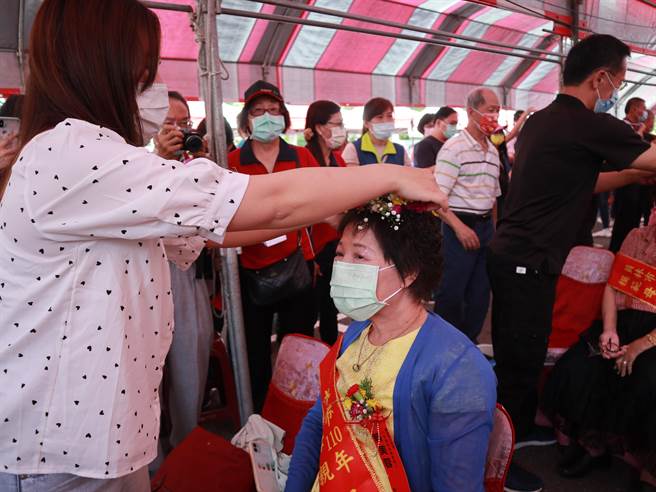 模范母亲的孩子们亲手奉上茶水、还献上美丽的花冠，户外举办除了减少室内群聚感染风险，接受表扬的母亲也能在桐花树下接受亲子的慰劳与感谢，好不浪漫。(吴建辉摄)