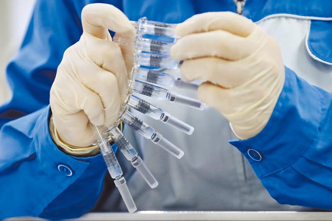 世卫组织7日正式批准中国国药集团的疫苗，纳入国际疫苗分享计画COVAX。图为中国疫苗包装线上人员在检查标籤。（新华社）