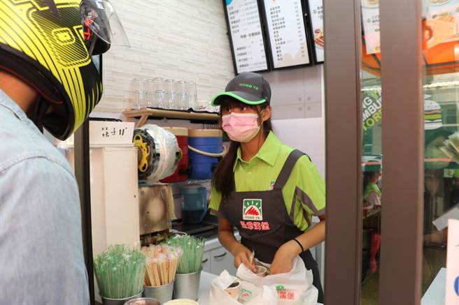 安安（化名）在公益早餐店为客人递上早餐和饮料（戴上容摄）