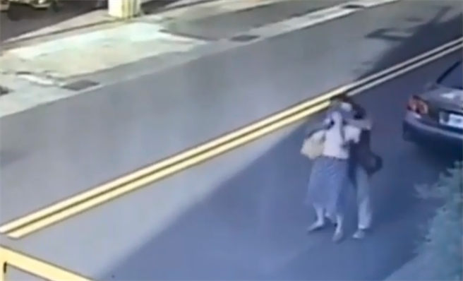 身穿红衣的廖趁林女不注意时，从后方抢走脖子上的K金项炼，得手后跑步离去，并骑上机车逃逸无踪。（陈世宗翻摄）