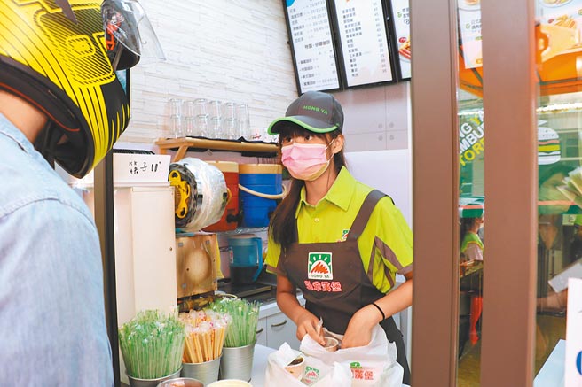公益早餐店的安安（化名）在店內為客人送上外帶早餐。（戴上容攝）