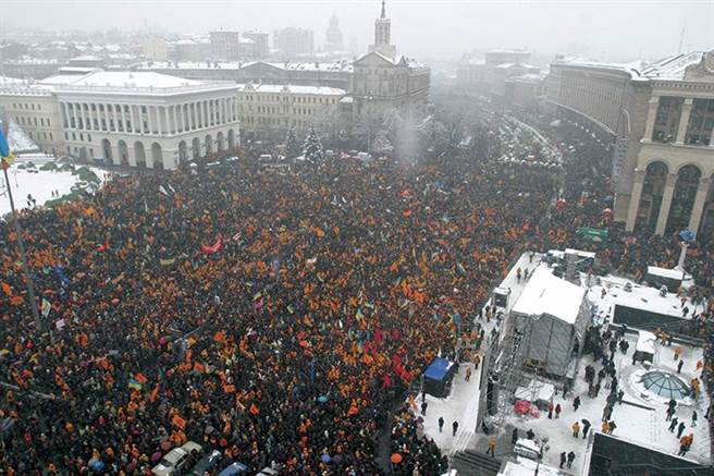 一般政治評論認為，2004年起由西方國家策動的「橙色革命」，在2014年時趕走了親俄的烏克蘭總統，是改變烏克蘭政局的關鍵事件。自此烏克蘭政治失序，族群與黨派惡鬥中逐漸沉淪。圖為2004年在基輔的橙色革命。（圖／推特@KatyaYushchenko）