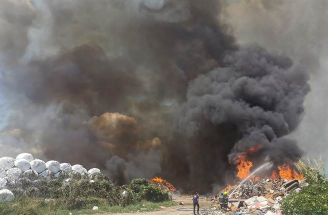 南投县名间乡一般废弃物掩埋场，12日上午11点左右发生垃圾燃烧，大量垃圾堆积物迅速延烧，消防队布水线灭火。（黄国峰摄）