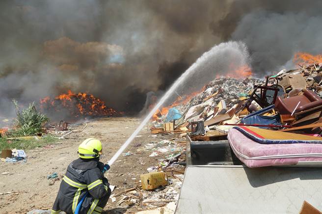 南投县名间乡一般废弃物掩埋场，12日上午11点左右发生垃圾燃烧，大量垃圾堆积物迅速延烧，消防队布水线灭火。（黄国峰摄）