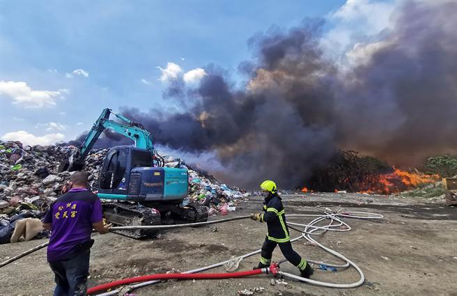 南投县名间乡一般废弃物掩埋场，12日上午11点左右发生垃圾燃烧，大量垃圾堆积物迅速延烧，快手挖开垃圾，协助消防队灭火。（黄国峰摄）