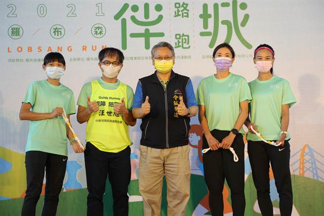 马拉松国手曹纯玉（左起）、罗布森董事长汪世旭、台中市副市长令狐荣达、及另两位国手谢千鹤、游雅君合影留念，3位国手手上拿着象徵「传递友善」的陪跑绳。（大会提供）