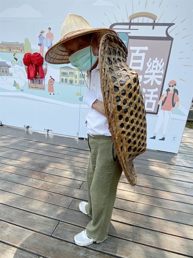 古农庄文物馆庄主张友吉亲自穿上古代农夫背在田间工作的雨具「龟壳笠」亮相。（陈淑芬摄）