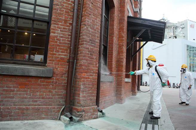 國內12日再增3起感染源不明本土個案，其中2確診都在台北市萬華區的茶室工作。圖為北市環保局人員在西門町紅樓周邊店家進行防疫消毒。（張鎧乙攝）