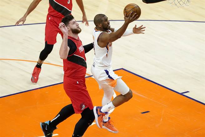 太阳后卫保罗闪过拓荒者中锋纽基奇的防守上篮取分。(美联社)