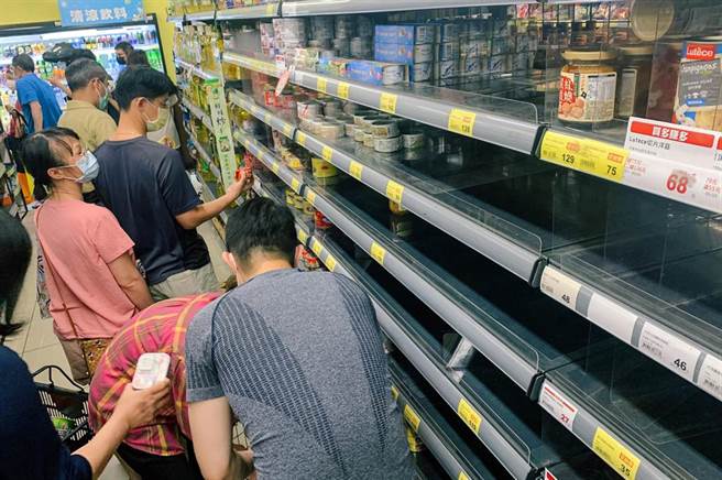 疫情再度升溫，雙北升為三級防疫警戒，15日中央開記者會後，賣場立刻湧入大批民眾搶購物資，許多乾糧架上被搶購一空，民眾只能望洋興嘆。（資料照）