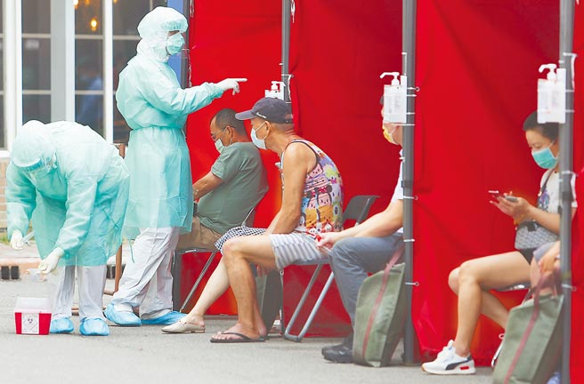 台北市万华地区爆发本土新冠疫情，已根据地缘关系发送细胞简讯给有染疫顾虑的市民前往採检站快筛，14日位于市立医院中兴院区的急诊室外面帐篷，不少接获讯息的民眾准备接受採检。（季志翔摄）