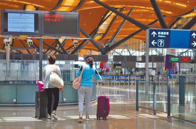 因应台湾新冠疫情升温，香港、澳门均升高对台湾入境的防疫要求。图为旅客走入港珠澳大桥香港口岸的出境大厅。（中新社）