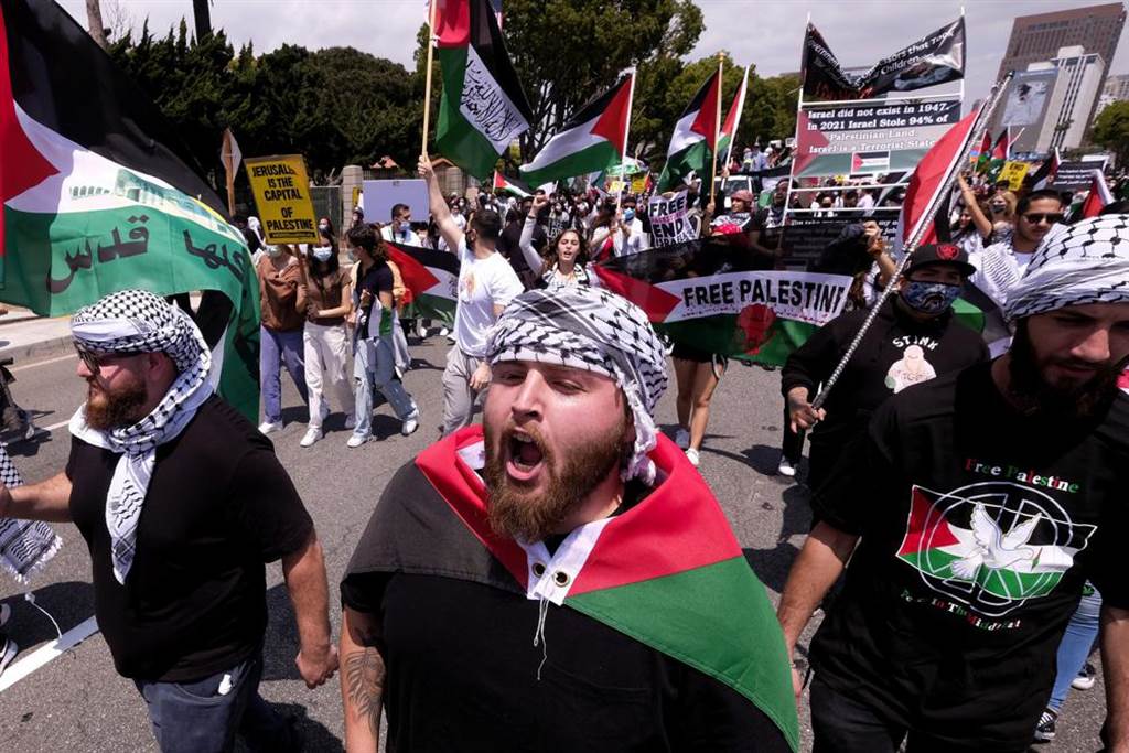 在洛杉矶的威斯伍德（Westwood）地区，示威者手持标志向以色列领事馆行进，以支持巴勒斯坦。图/美联社(photo:ChinaTimes)