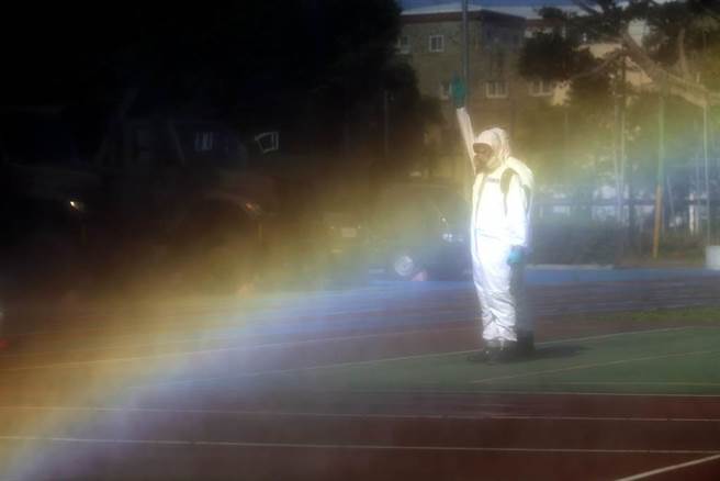 国内疫情严峻，随处可见陆军化学兵以及民间消毒团体为环境清消。图为陆军化学兵在出发前测试喷洒消毒机具，瀰漫空中的消毒水经过阳光的照射，折射出一道美丽的彩虹。（资料照，黄世麒摄）
