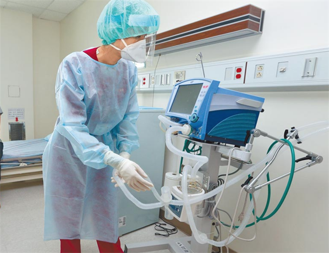 双北病房告急，只剩209专责病床。图为护理人员全副武装穿上隔离衣接收病患送到负压病房后，整理呼吸器。（本报资料照片）
