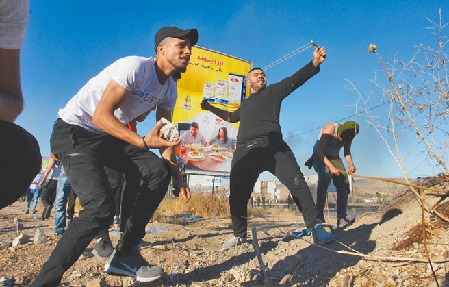 以巴衝突持续延烧，巴勒斯坦民眾在约旦河西岸，向以色列士兵投掷石块。（新华社）