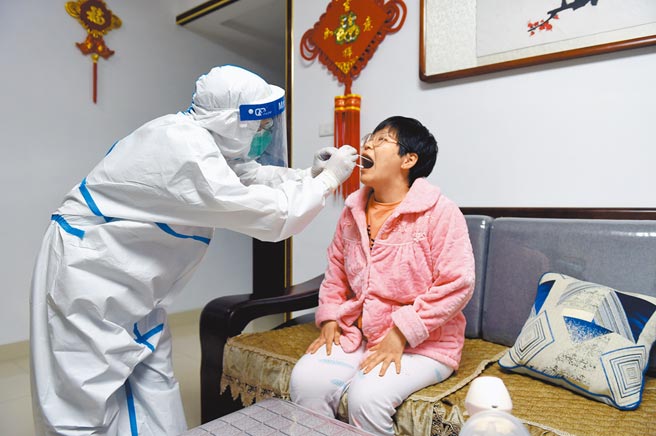 安徽市裕安区和顺社区，医护人员上门为不便外出的居民做核酸检测。（新华社）