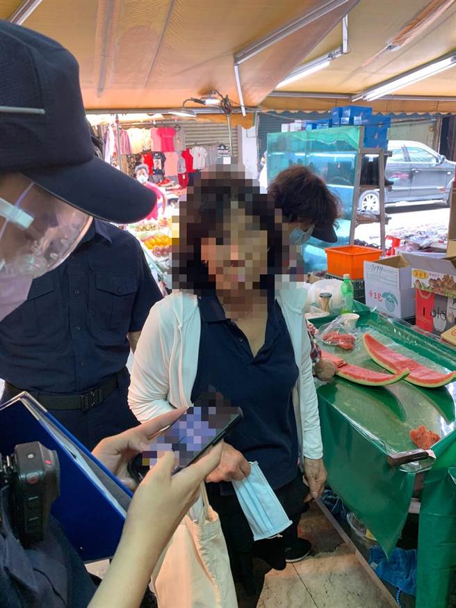69歲呂姓婦人在湧蓮寺市場買菜時將口罩拿在手上，遭警方取締通報衛生局依法開罰3000至1萬5000元罰鍰。（蘆洲警分局提供）