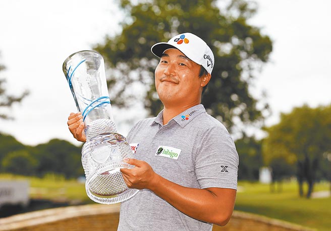 韩国选手李京勋拿着尼尔森菁英赛冠军奖杯开心合影。（美联社）