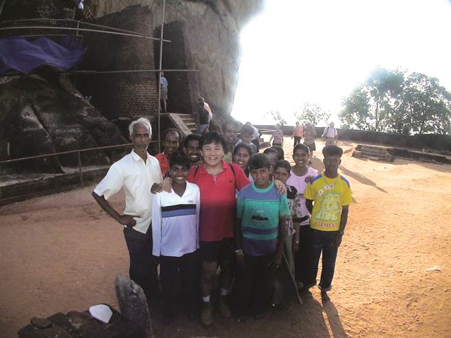 大石狮脚爪前我和斯里兰卡正要下山的民眾们合影。(《每一趟旅行都是爱与梦的分享》/四块玉文创)
