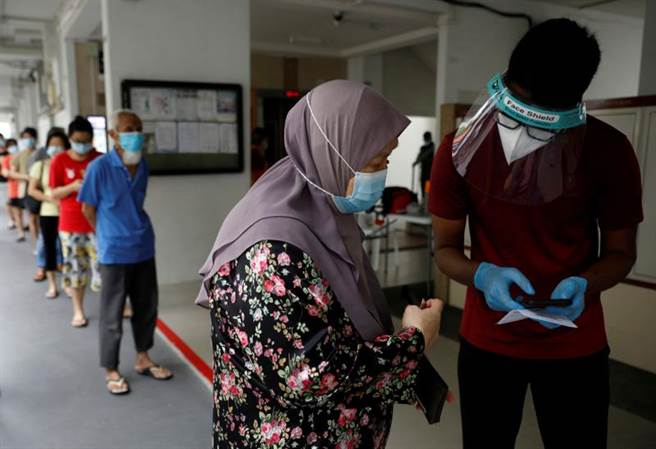 新加坡近期新冠肺炎疫情也升溫，圖為新加坡民眾接受病毒檢測。（圖／路透社）