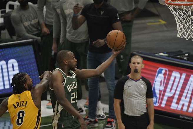 公鹿前锋米德顿成功闪过热火前锋阿里查的防守上篮。(美联社)