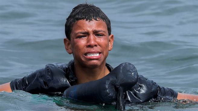 摩洛哥少年日前靠着塑胶空瓶漂流至西班牙，一上岸就遭到士兵带走。（图／路透）