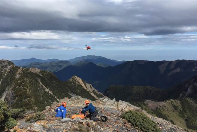 新竹县消防局山难搜救小组在品田山等待直升机将坠崖罹难者运送下山。（新竹县消防局提供／罗浚滨新竹传真）