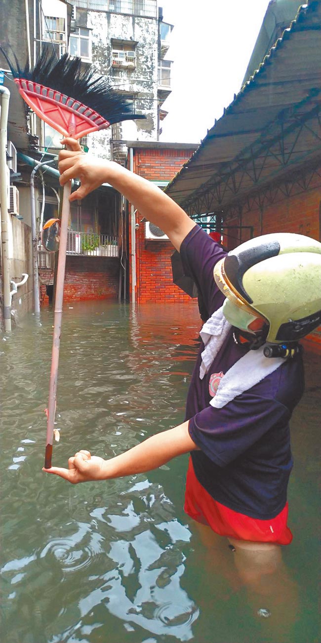 台北市24日午后一场雷阵雨下得又急又快，内湖东湖路58巷一度水深约1公尺，有民眾拿出扫把测量积水深度。（台北市水利处提供／张立勋台北传真）
