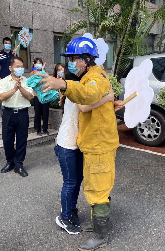 阿里山工作站技正陳志銀（右），從水漾森林打火後又趕到玉山八通關繼續執勤，已半個月沒回家，老婆開心衝上前擁抱。（嘉義林管處提供／張亦惠嘉縣傳真）