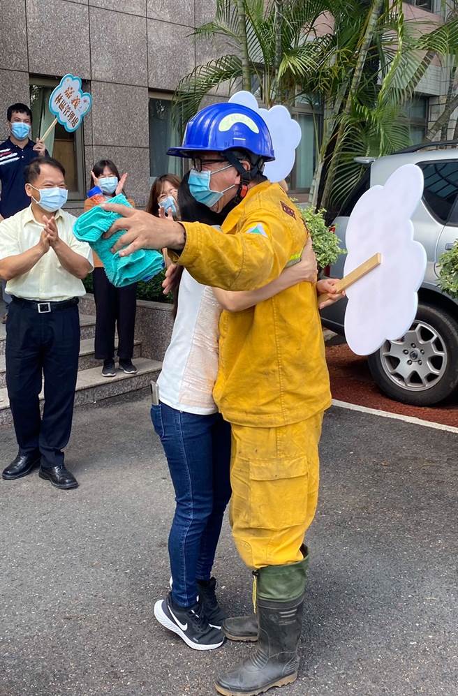 完成玉山任务的打火英雄光荣返队，被妻子紧紧拥在怀中。（翻摄脸书「林务局-森活情报站」）