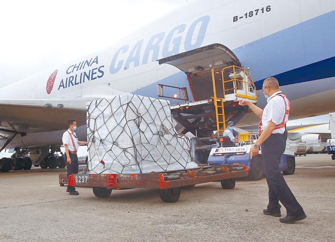 首批美國莫德納疫苗由華航貨機載運，28日抵達桃園機場，地勤人員將貨櫃卸下，立即送往醫藥物流冷鏈倉儲存放。  （范揚光攝）