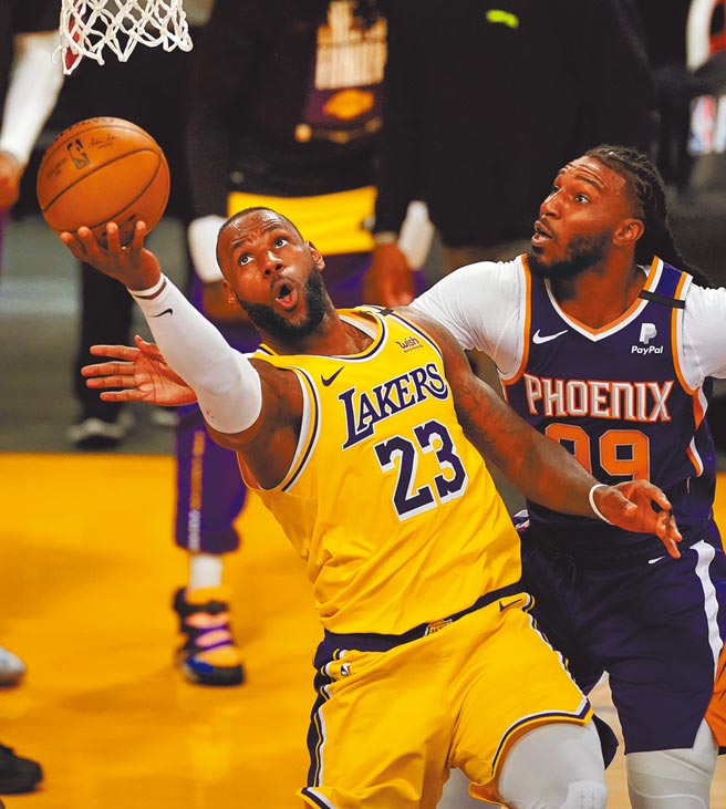 湖人「小皇帝」詹姆斯（左）强攻太阳禁区反手挑篮。（路透）