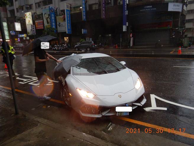 蓝宝坚尼疑雨中打滑，衝撞分隔岛上路灯连根拔起。（民眾提供／陈世宗台中传真）