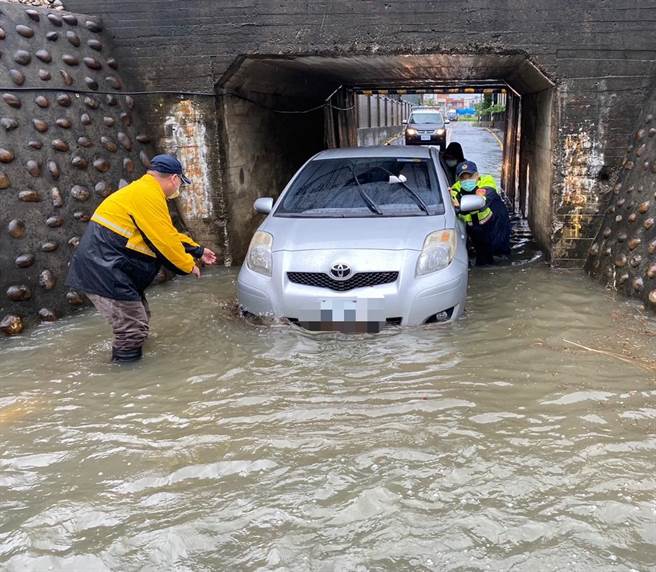 日南派出所长邱量虔与同仁涉水将车子推出涵洞。（大甲警分局提供／陈淑娥台中传真）
