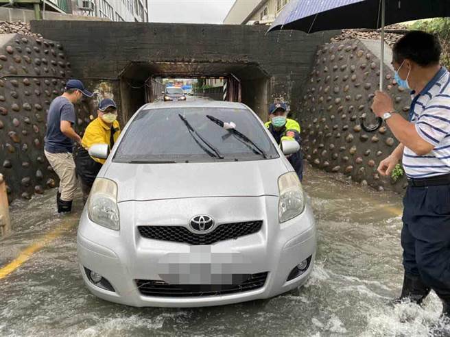 日南派出所长邱量虔与同仁涉水将车子推出涵洞。（大甲警分局提供／陈淑娥台中传真）
