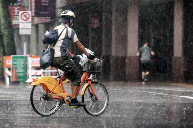 由于锋面笼罩台湾地区，台湾各地31日普遍降下间歇性大雨，台北市因疫情加上大雨，未带雨具出门的路人，只好往前衝。（邓博仁摄）

