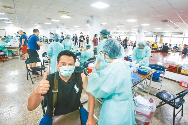 台北市成德市场30日设置疫苗注射点，台北市政府针对环保局、卫生局、消防局等一线人员施打，一位正在施打的民眾对着镜头竖起大拇指比讚。（邓博仁摄）