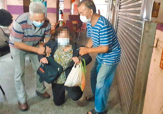 基隆一名妇人（中）在LINE群组转传自来街一间中药房老板夫妻俩确诊死亡假消息，得知讯息错误后，5月31日到中药房向老板道歉，甚至一度下跪磕头。（中央社）