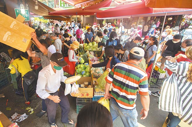 新冠肺炎疫情升溫，雙北15日升級三級警戒，傳統市場仍舊人聲鼎沸，許多民眾前往採買蔬果，雖有戴口罩，但仍難以維持安全社交距離。（杜宜諳攝）
